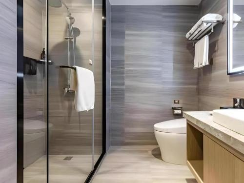 un bagno con doccia, WC e lavandino di Gya Hotel Wuxi Hubin Commercial Street Tai Lake Scenic Area a Wuxi
