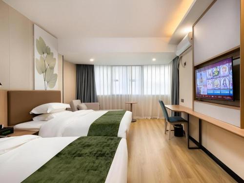 a hotel room with two beds and a flat screen tv at GreenTree Inn Express Fujian Ningde Ningchuan Road Qinghua Building in Ningde