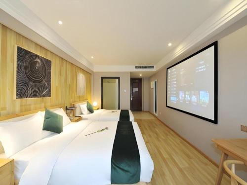 a large white bed in a room with a projection screen at VX Hotel Chengdu Shuangliu Airport Sainawei in Chengdu