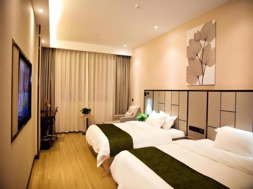 a hotel room with two beds and a television at GreenTree Inn Xinjiang Kashgar Food Street in Kashgar