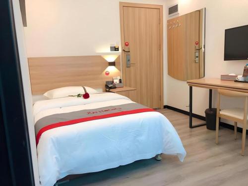 a hotel room with a bed and a desk at Jun Hotel Guangdong Zhanjiang Xiashan South Railway Station in Zhanjiang