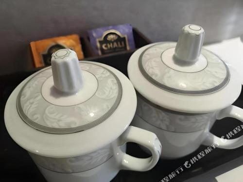 two white cups with wrappers on top of them at Borrman Hotel Liuzhou High-Speed Railway Station in Liuzhou