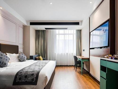 a hotel room with a bed and a desk at GEM Hotel Changzhou Xuejia'aoyuan North High-Speed Railway Station in Changzhou
