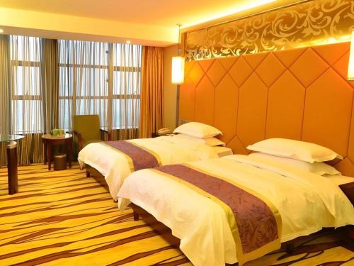 a hotel room with two beds in a room at VX Hotel Chengdu Jiaolong Port Haibin in Chengdu