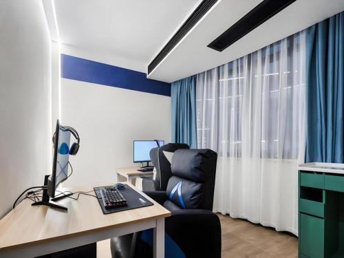 an office with a desk and a chair and a computer at GEM Hotel Changzhou Xuejia'aoyuan North High-Speed Railway Station in Changzhou