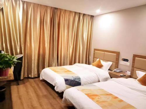 a hotel room with two beds and a window at Shell Hotel Jiangsu Taizhou Hailing District Taizhou Avenue in Sixiang