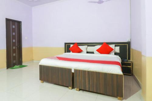 une chambre avec un grand lit avec des oreillers rouges dans l'établissement Hotel O Sunrise Inn, à Indirapuram