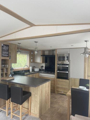 a kitchen with wooden cabinets and a black counter top at New Forest holiday lodge in New Milton