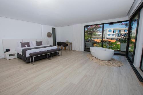 a bedroom with a bed and a tub in a room at Golden Bay Galapagos in Puerto Baquerizo Moreno