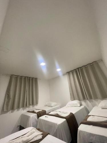 a room with three beds and two windows at Rede de Hotel 99 in Garanhuns