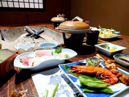 a table topped with different types of food on plates at 咲花温泉 ホテル丸松 in Gosen