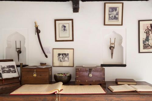a room with pictures on the wall and a table with papers at Ahilya Fort in Maheshwar
