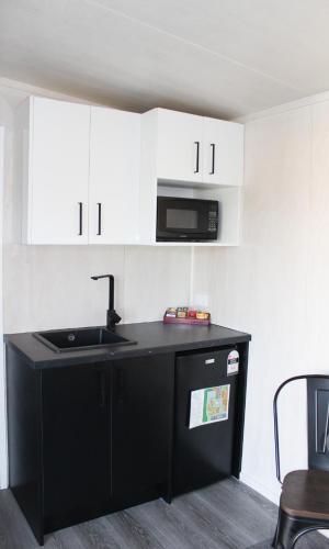 a kitchen with a black sink and a microwave at Whanganui Seaside Holiday Park in Whanganui