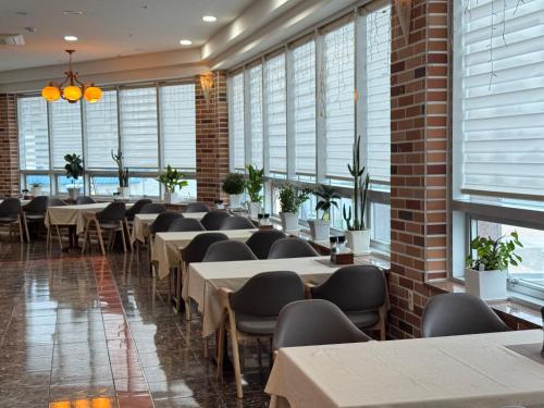 a row of tables and chairs in a room with windows at Geoje Ocean Hotel in Geoje 