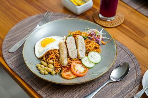 een bord eten met eieren en noedels op een tafel bij Novancha Villa in Ubud