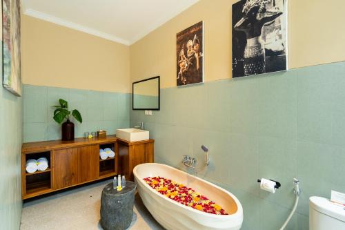 baño con bañera llena de flores en Novancha Villa, en Ubud