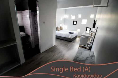 a living room with a bed and a white room at Kaoseng Rockhill Hotel in Songkhla