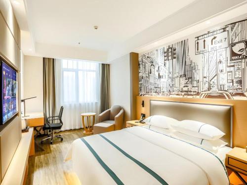 une chambre d'hôtel avec un grand lit et une télévision dans l'établissement City Comfort Inn Yidu Three Gorges Qianguqing Wanda Plaza, à Yichang