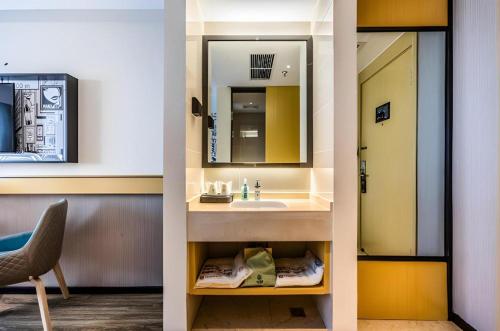 - deux vues sur une salle de bains pourvue d'un lavabo et d'un miroir dans l'établissement City Comfort Inn Handan New Century Plaza, à Sucao