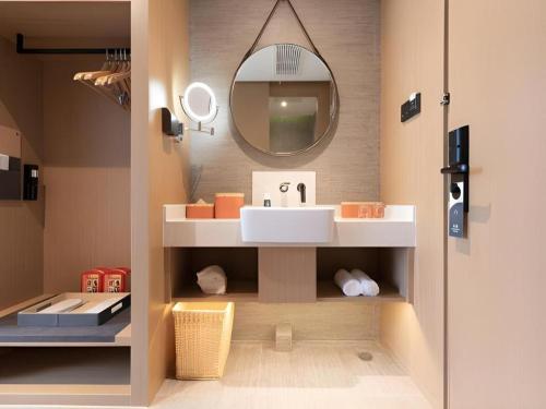 a bathroom with a sink and a mirror at Atour Hotel Huainan Railway Station Commercial and Cultural Square in Huainan