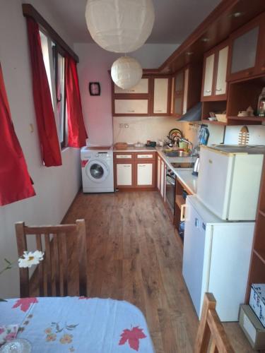 a small kitchen with a white refrigerator and a table at Sea view apartment in Tsarevo