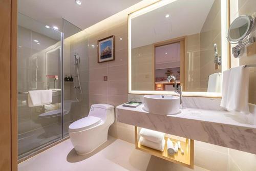a bathroom with a toilet and a sink and a shower at Vienna Hotel Chongqing West Station Square in Chongqing