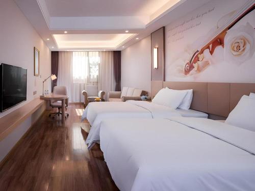 a hotel room with two beds and a flat screen tv at Vienna Hotel Yunnan Dali Ancient City Scenic Spot in Dali Ancient Town