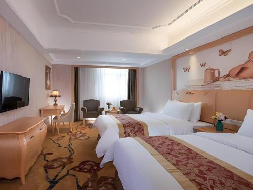 une chambre d'hôtel avec deux lits et une télévision dans l'établissement Vienna Hotel Shenzhen Pingdi Huancheng South Road, à Longgang