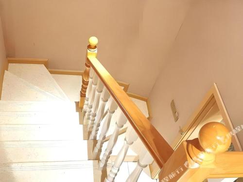 a stairway with a wooden rail and a stair case at Vienna Hotel Chengdu Exhibition Center In Time City in Chengdu