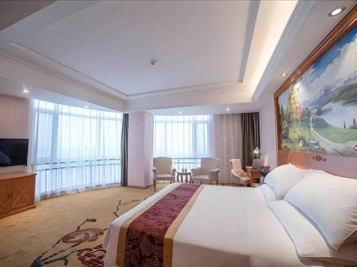 une chambre d'hôtel avec un grand lit et une télévision dans l'établissement Vienna Hotel Hebei Tangshan Nanhu Park, à Tangshan