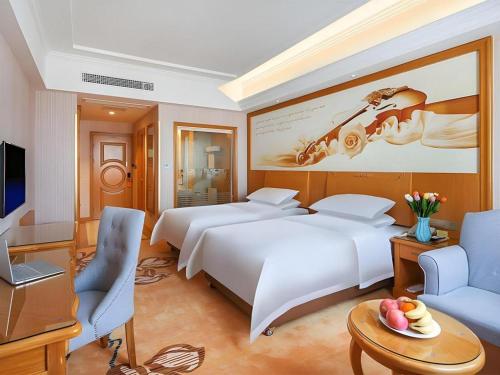 a hotel room with two beds and a television at Vienna Hotel Taicang Shanghai East Road Landu Branch in Zhoujiating