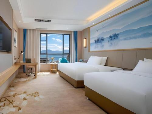 a hotel room with two beds and a television at Vienna Hotel Yunnan Dali Erhai Lake in Dali