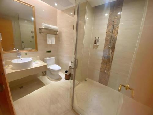 a bathroom with a shower and a toilet and a sink at Vienna Hotel Guangdong Shantou South Bus Station in Shantou