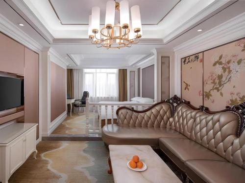 a living room with a couch and a table at Vienna Hotel Guangdong Shantou South Bus Station in Shantou