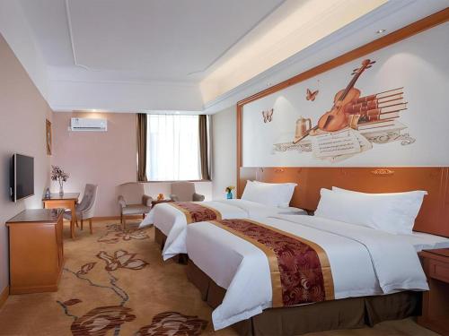 a hotel room with two beds and a television at Vienna Hotel Guangdong Dongguan Chengnan Station in Dongguan