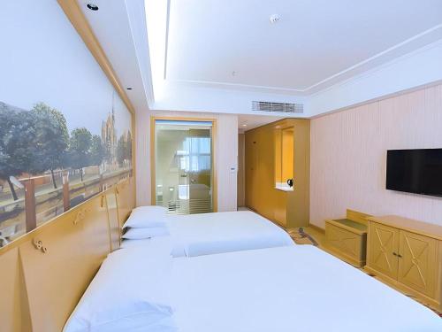 Ένα ή περισσότερα κρεβάτια σε δωμάτιο στο Vienna Hotel Hubei Xiangyang Tang City Gulou