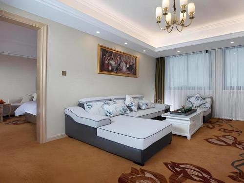 a living room with a couch and a bed at Vienna Hotel Fujian Yong'an South Railway Station in Sanming
