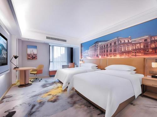 a hotel room with four beds and a painting on the wall at Vienna Hotel Anhui Bengbu Free Trade Zone in Bengbu