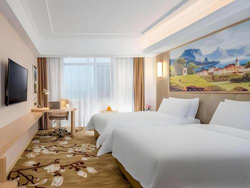a hotel room with two beds and a television at Vienna Hotel Shandong Qingdao Jiaodong International Airport Hai'er Avenue in Qingdao