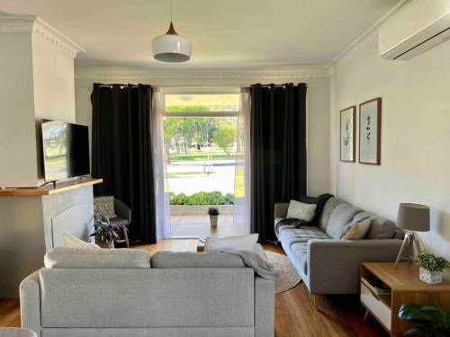 a living room with two couches and a large window at Mildura Park Views in Mildura