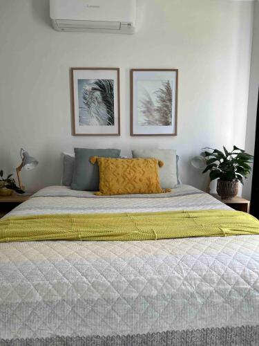 a bedroom with a bed with a yellow pillow on it at Mildura Park Views in Mildura