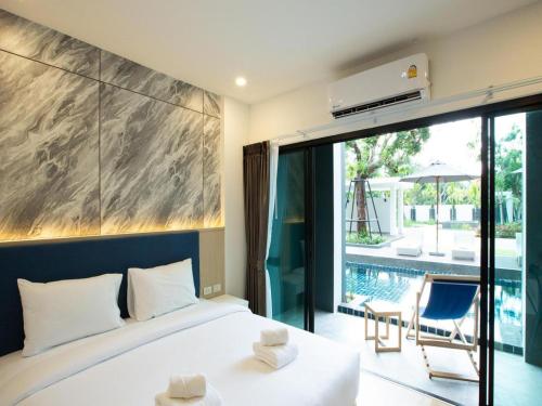 Un dormitorio con una cama y vistas a una piscina. en B2 Krabi Ao Nang Premier Resort, en Ao Nang 
