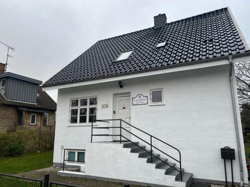 a white building with a black roof and stairs at Casa de Rainer Copenhagen Room 2 in Copenhagen