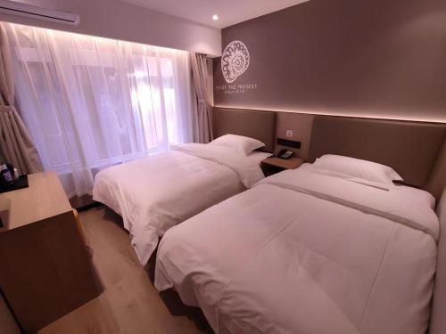 a hotel room with two beds and a window at Shell Hotel Beijing Shunyi District Shunyi Metro Station in Beijing