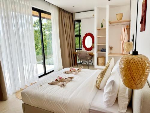 a bedroom with a large white bed with a large window at Sunset 3 Bedroom Sea View Villa with Infinity Pool in Chalok Ban Kao in Hinkong