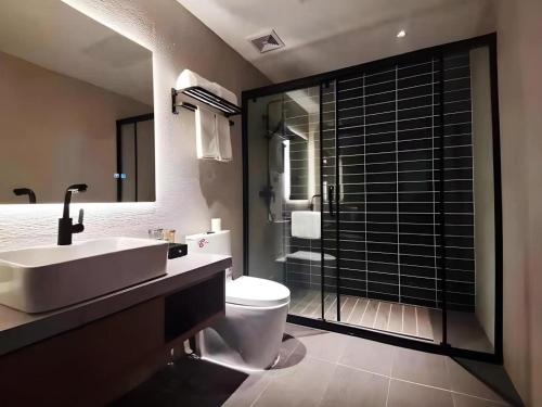 a bathroom with a sink and a toilet and a shower at Green Tree Inn Luoyang Fenghuang Mansion Mudan Square Metro Station in Luoyang