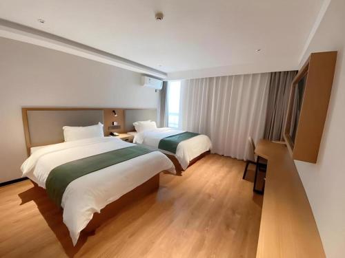 a hotel room with two beds and a television at Green Tree Inn Luoyang Fenghuang Mansion Mudan Square Metro Station in Luoyang