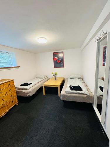 a room with two beds and a table in it at Casa de Rainer Copenhagen Room 2 in Copenhagen