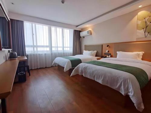 a hotel room with two beds and a large window at Green Tree Inn Luoyang Fenghuang Mansion Mudan Square Metro Station in Luoyang