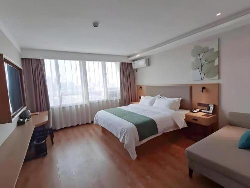 a hotel room with a bed and a couch at Green Tree Inn Luoyang Fenghuang Mansion Mudan Square Metro Station in Luoyang